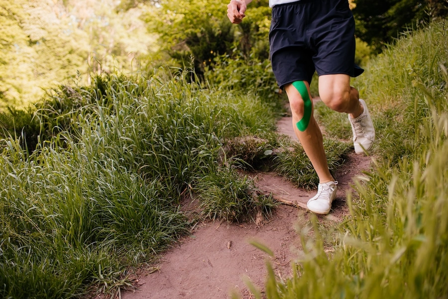 Older adult holding knee while seated, experiencing osteoarthritis pain before GAE