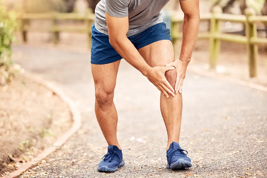 Man running outdoors with knee pain
